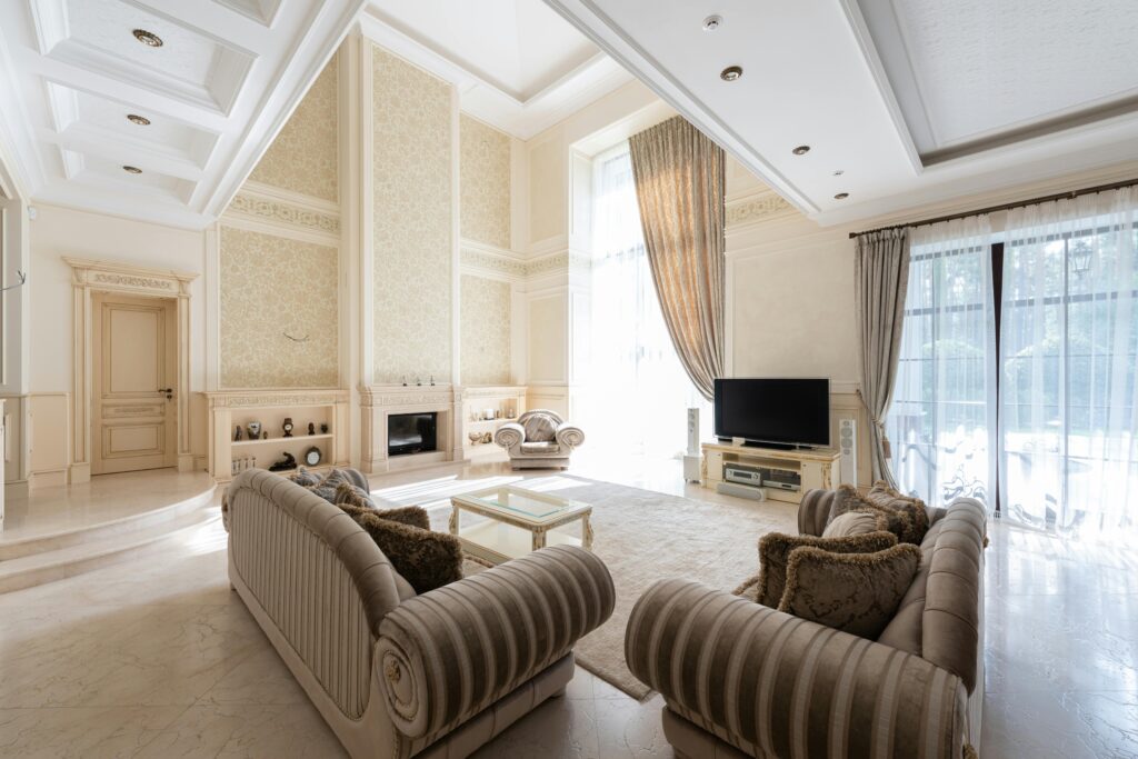 pexels-photo-7174113-7174113 Luxurious and spacious living room with elegant decor, rich textures, and large windows.